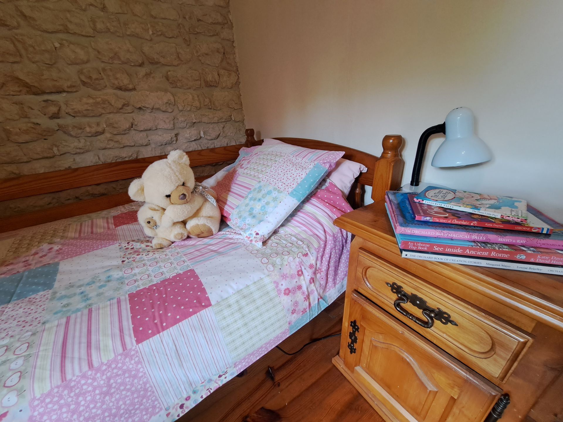 childs bed with teddy bear and childrens books