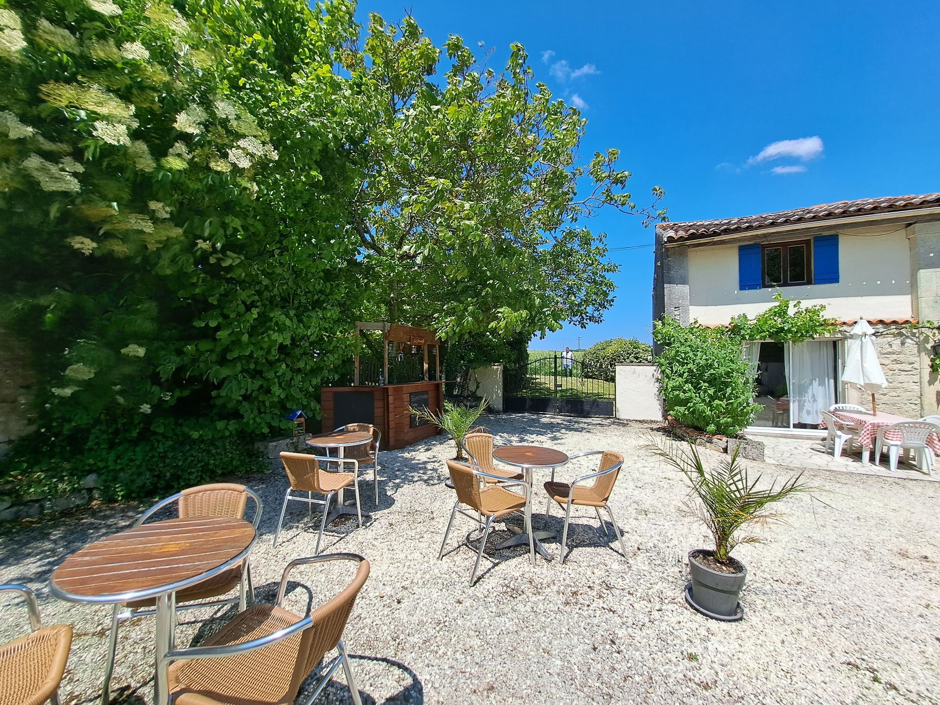 café tables and chairs and a cottage in the background