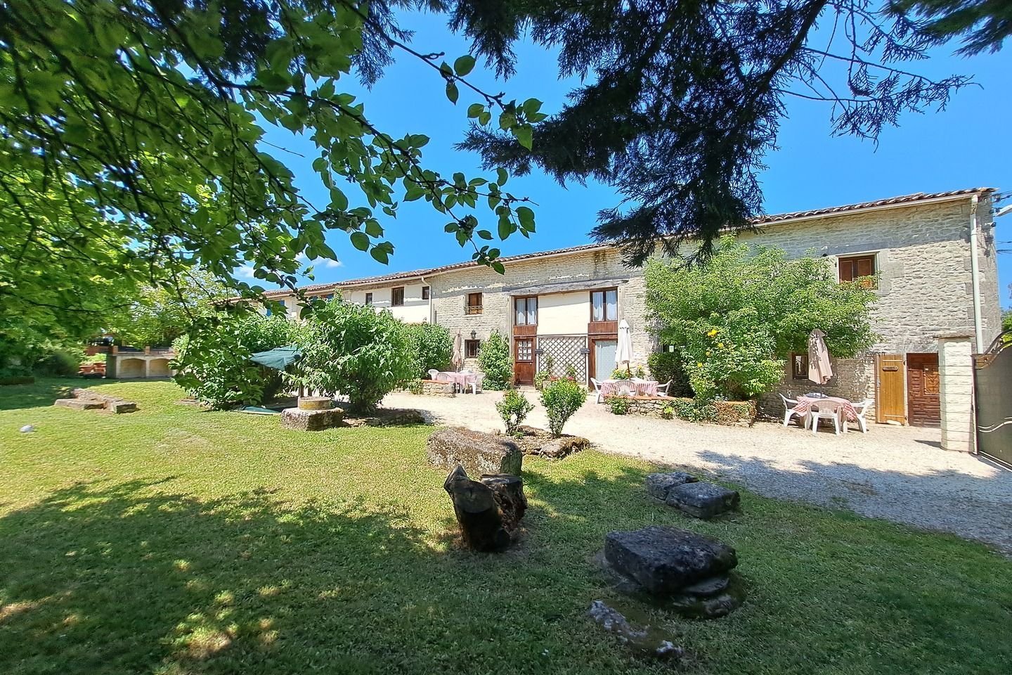 view through branches of a tree of a row of stone cottages