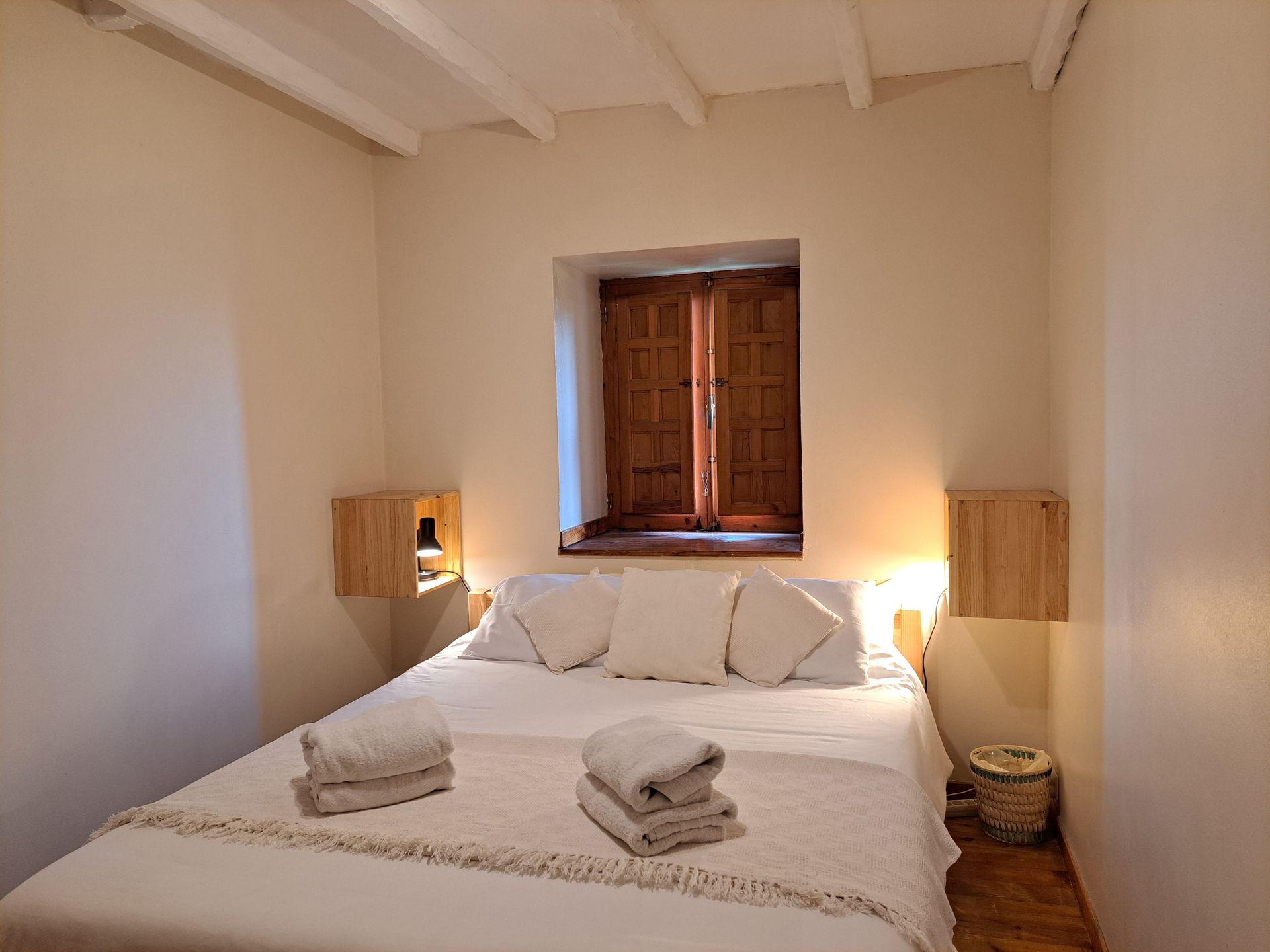 king sized bed with white bedding and cushions