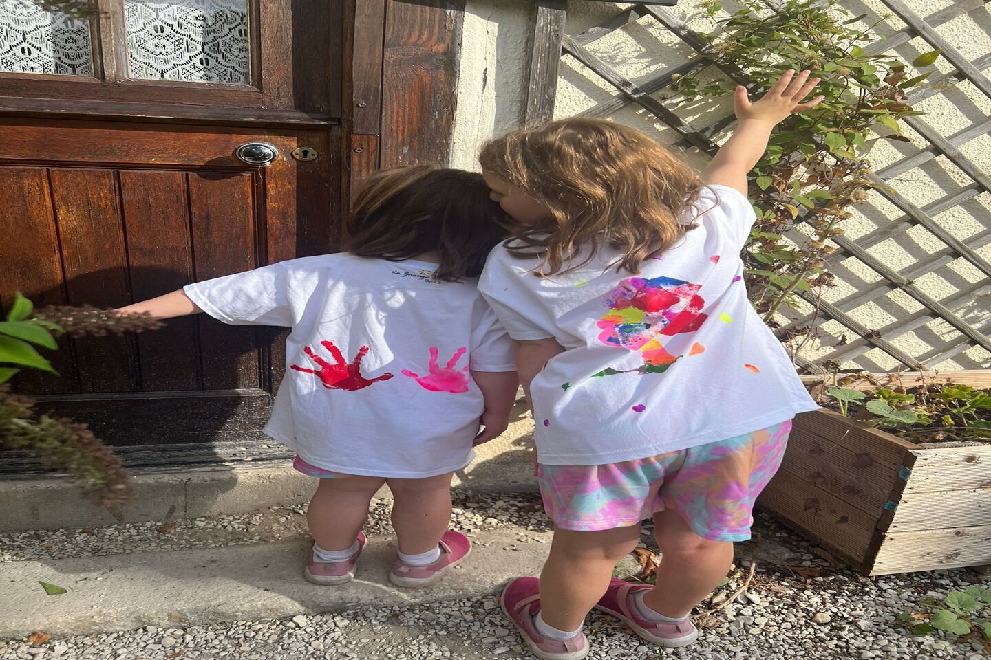 two children showing the backs of their t-shirts they painted