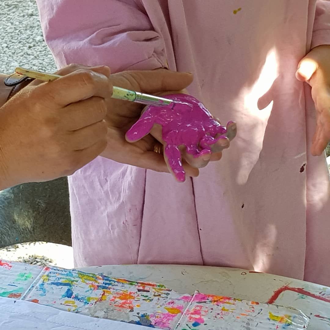 child having their hand painted pink