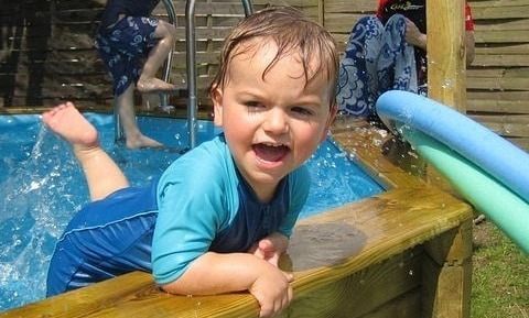 toddler splashing in a pool