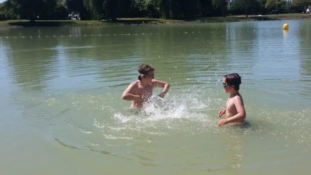 child splashing in a lake