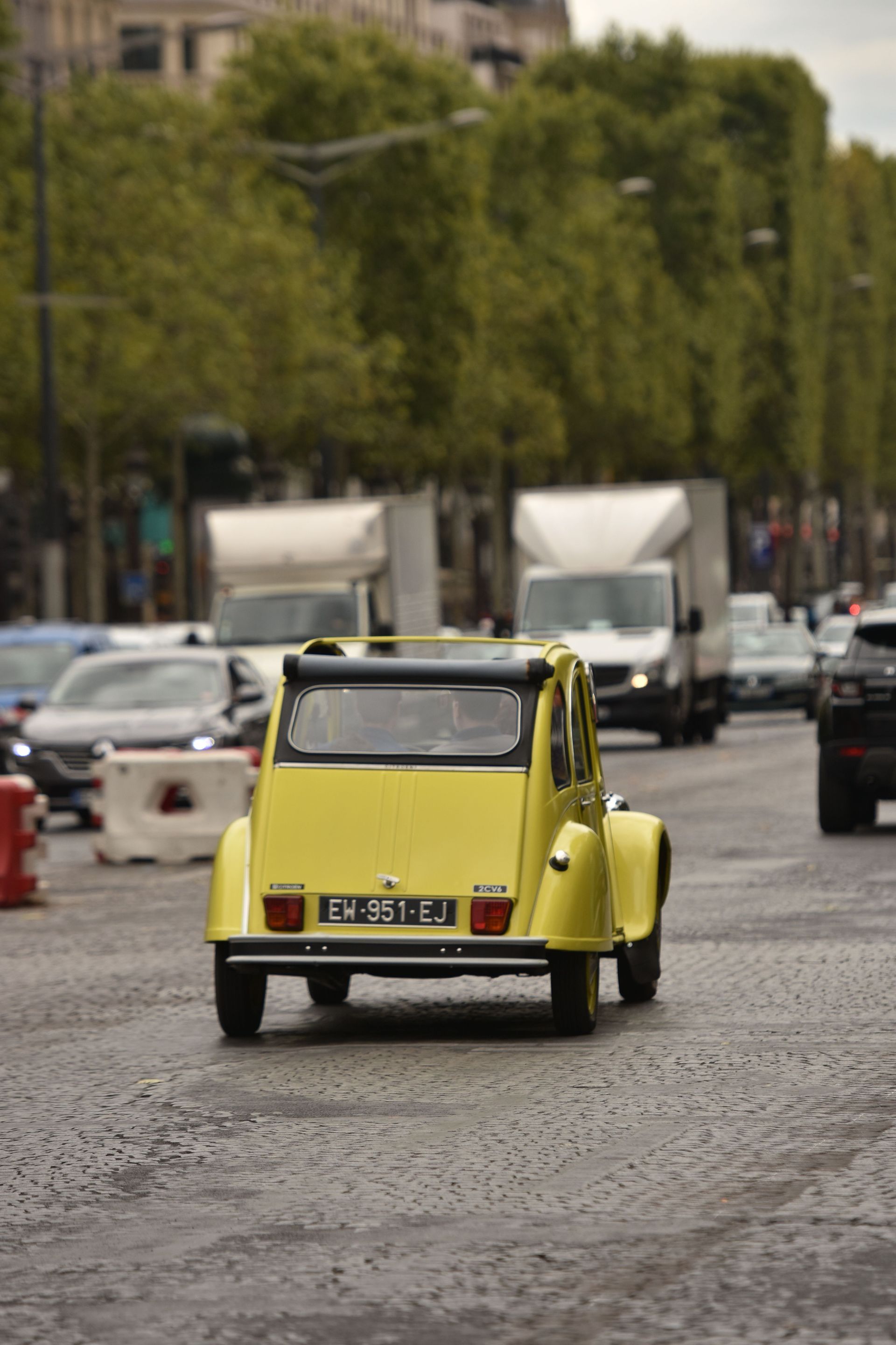 lime green Citroen cv driving along a French boulevard