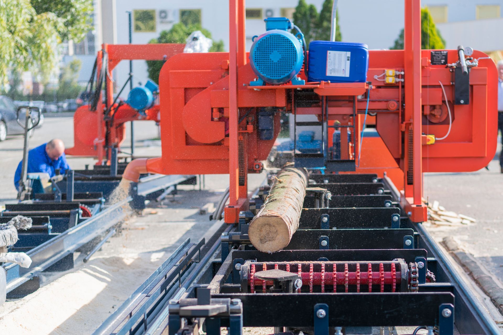 A man is working on a machine that is cutting a log.
