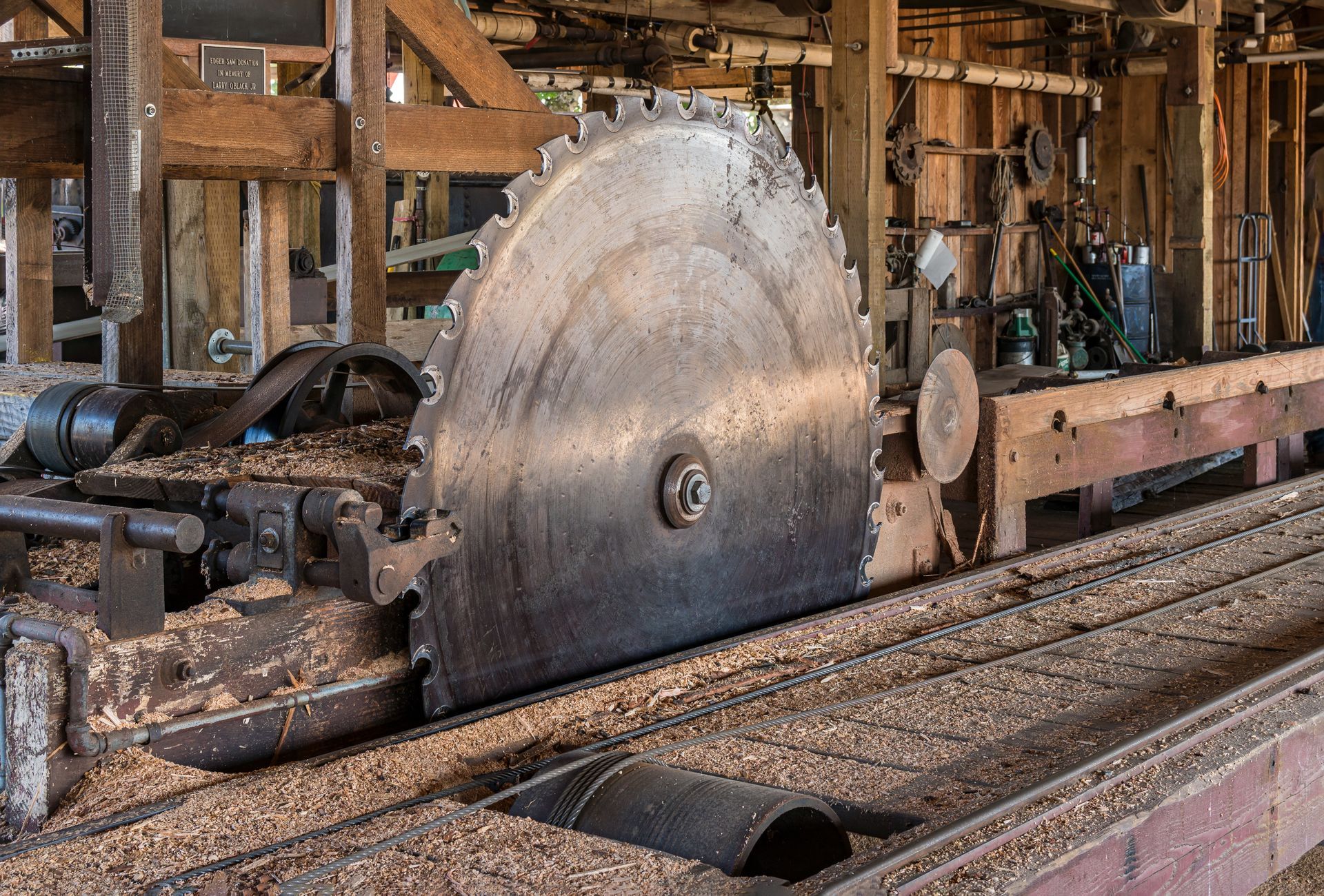 A large circular saw is cutting a piece of wood