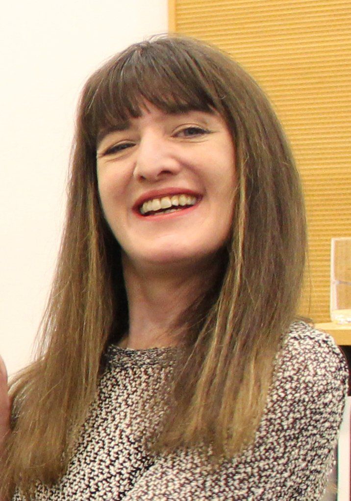 Head and shoulders photo of Ema, who has long straight brown hair and is smiling.