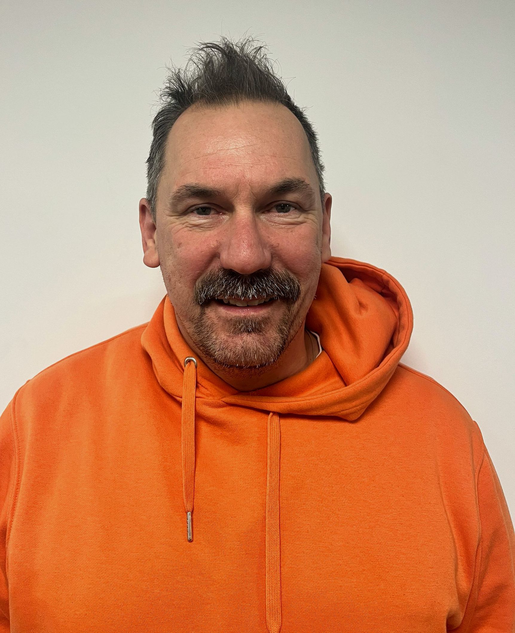 Photo of Cat, who has long dark hair and is wearing an orange top.