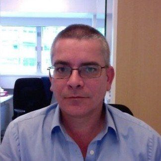 A head and shoulders photo of Miles, who has short, cropped hair and is wearing glasses.