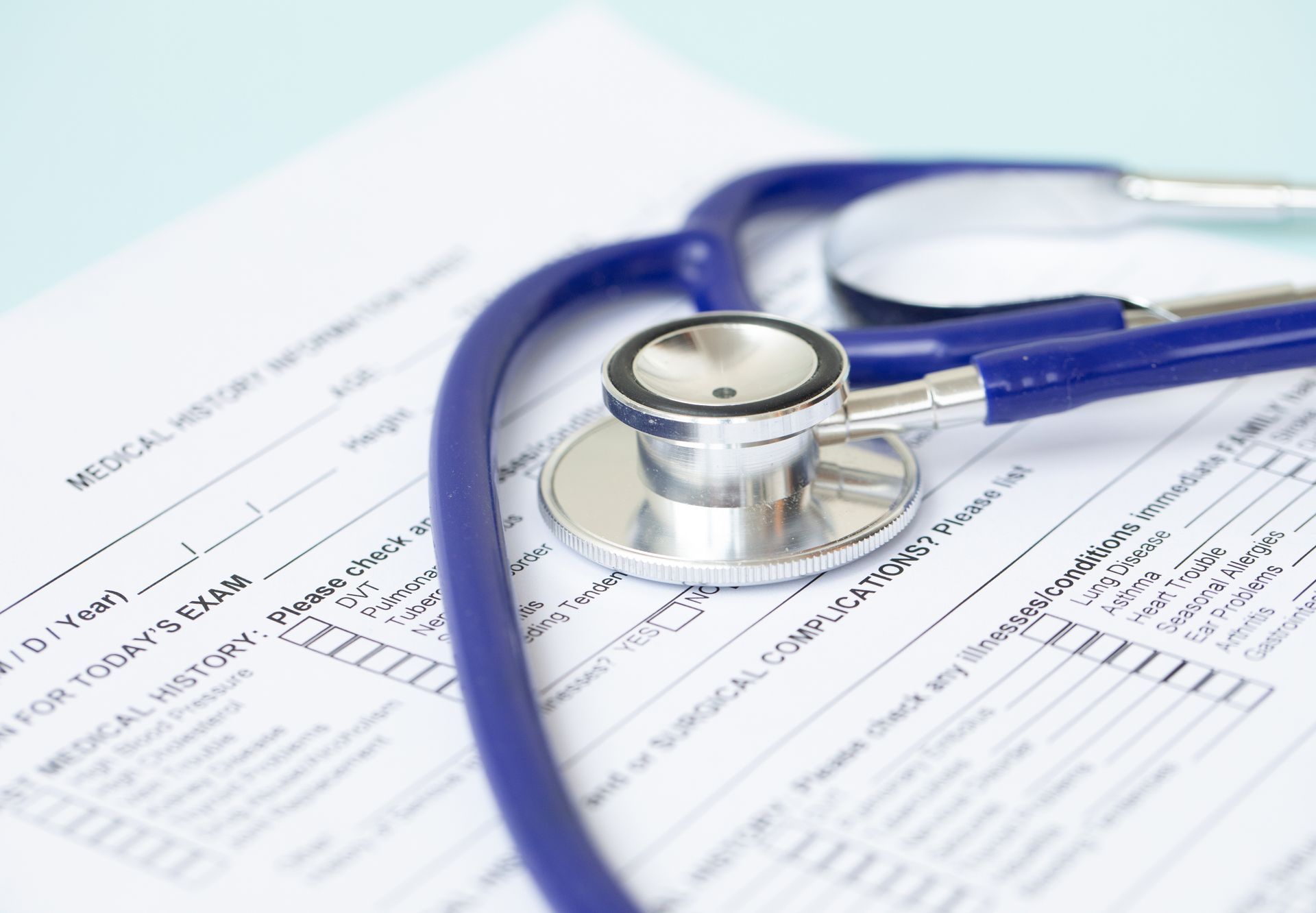 Blue stethoscope on medical history form.