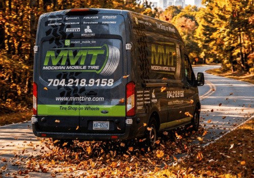 Modern Mobile Tire service van driving along a winding road surrounded by colorful fall foliage