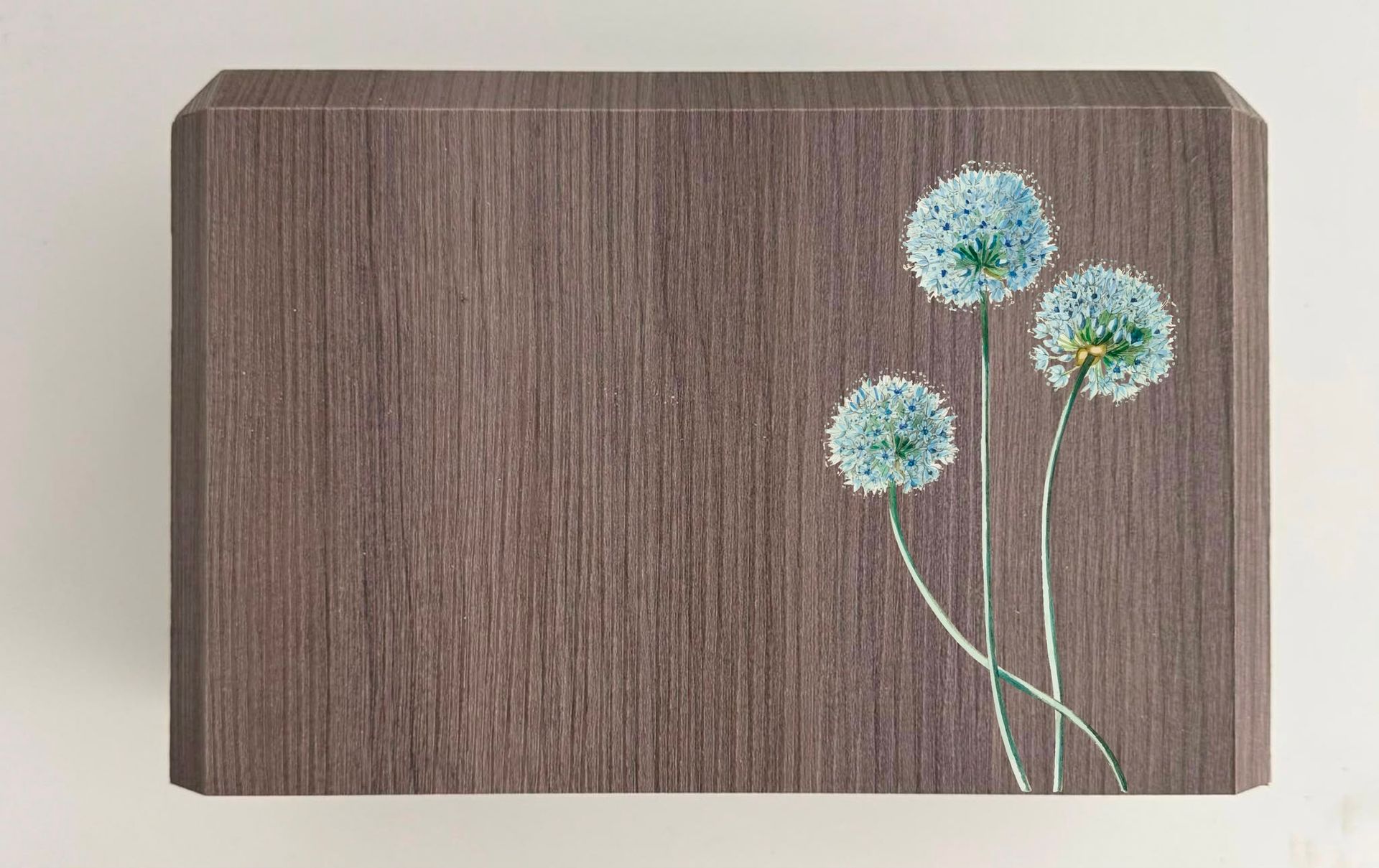 Pannello marrone testurizzato con tre fiori azzurro pallido su steli sottili nell’angolo in basso a destra