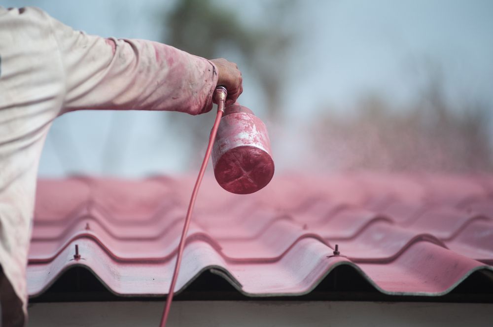 Person Sprays Red Paint Onto a Corrugated Roof — CP Roofing in Old Bar, NSW