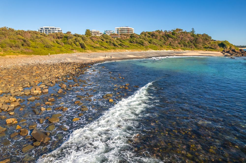 Rocky Coastline With Turquoise Water and a Breaking Wave — CP Roofing in Tuncurry, NSW
