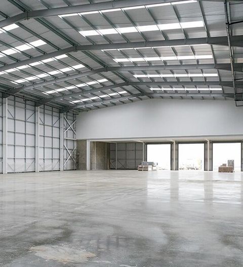 Large Empty Warehouse With a Concrete Floor — CP Roofing in Forster, NSW
