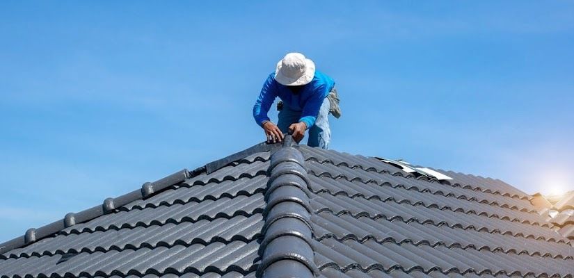 Man is Working on the Roof of a House — CP Roofing in Taree, NSW