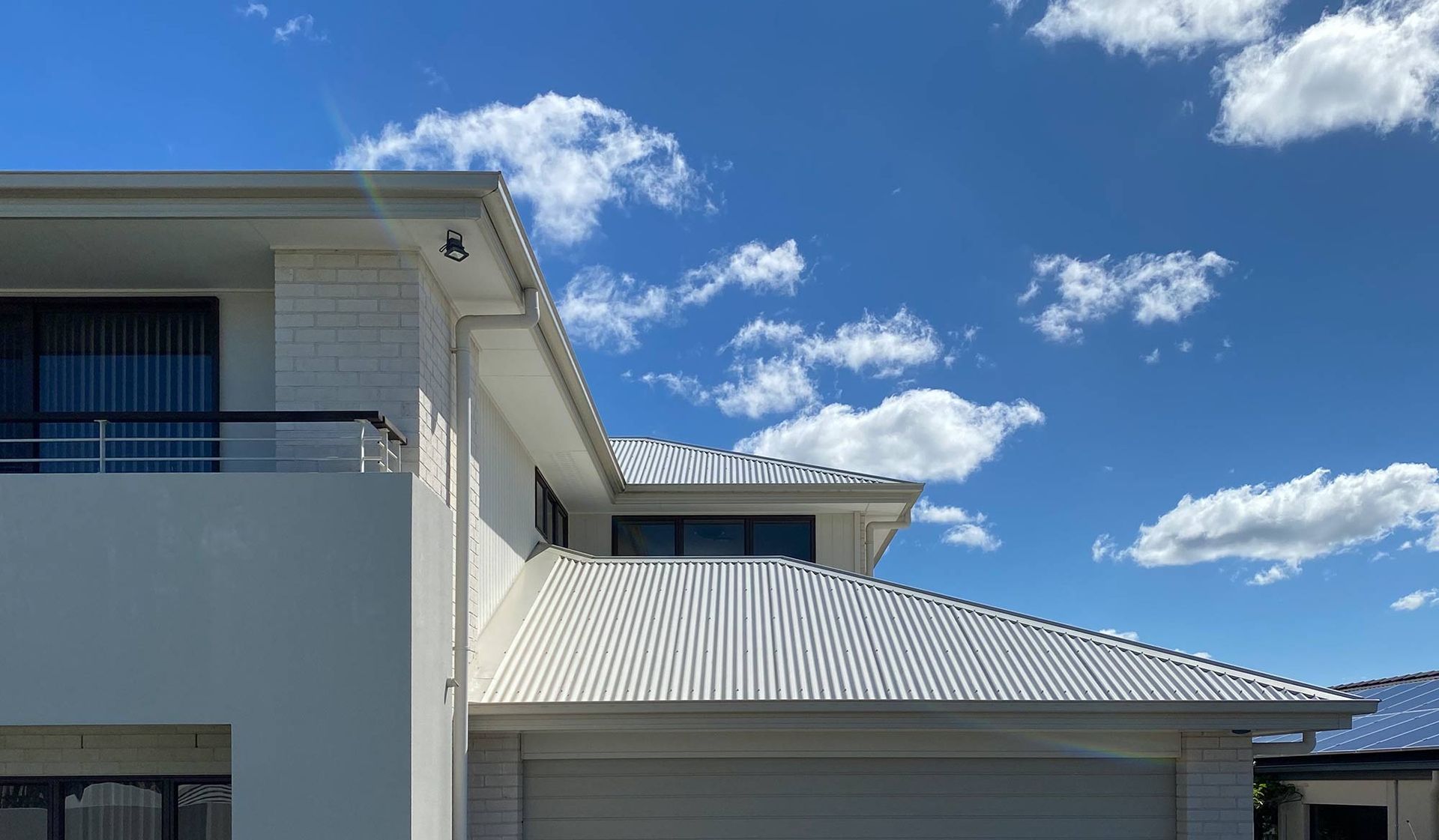White House With a Blue Sky and Clouds in the Background — CP Roofing in Old Bar, NSW