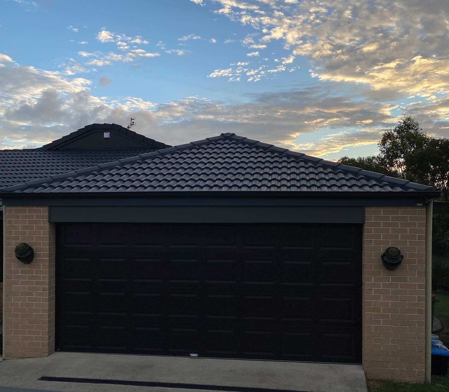 House With a Black Garage Door and a Blue Roof — CP Roofing in Taree, NSW