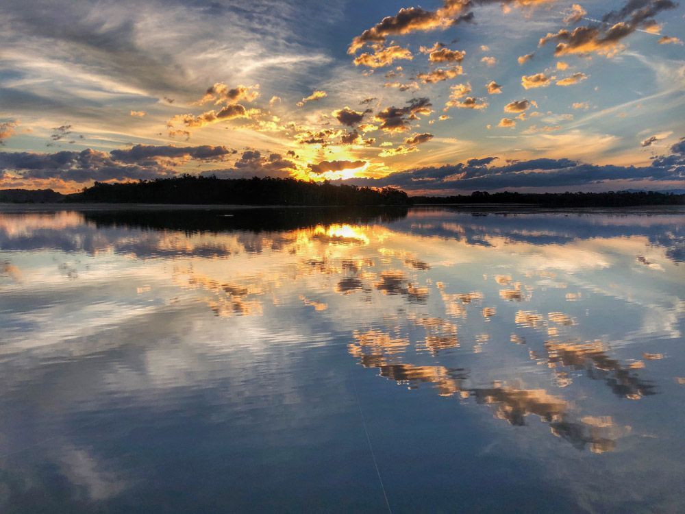 Sunset Over a Lake With Clouds Reflected in the Water — CP Roofing in Old Bar, NSW