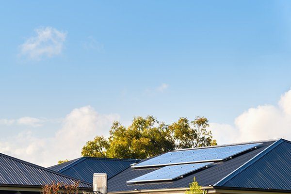 House With Solar Panels on the Roof on a Sunny Day — CP Roofing in Taree, NSW