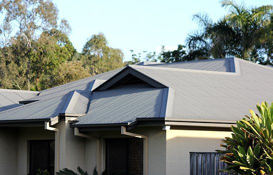 House With a Gray Roof and Trees in the Background — CP Roofing in Gloucester, NSW