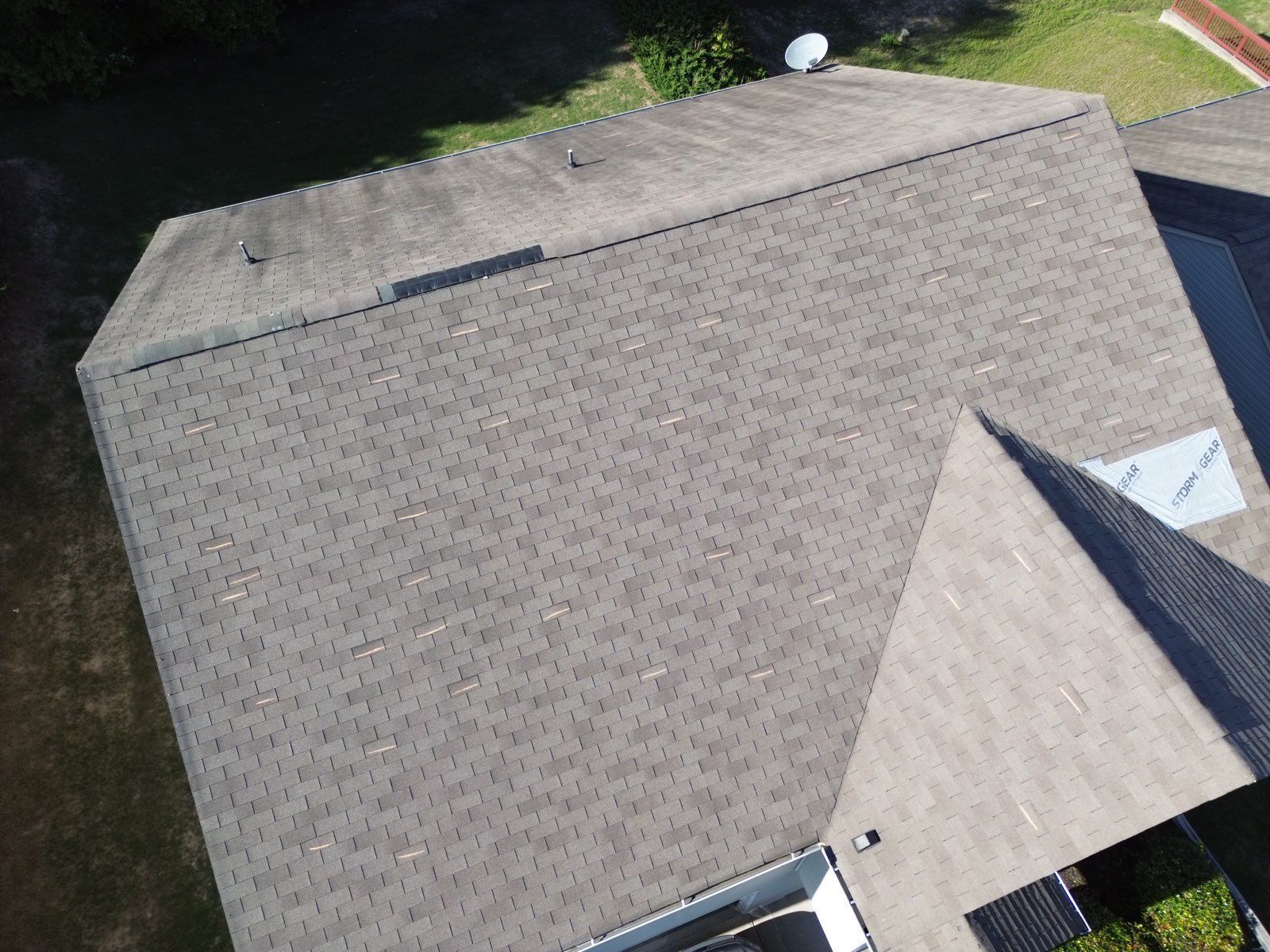 Overhead view of a house roof with gray shingles and several skylights.
