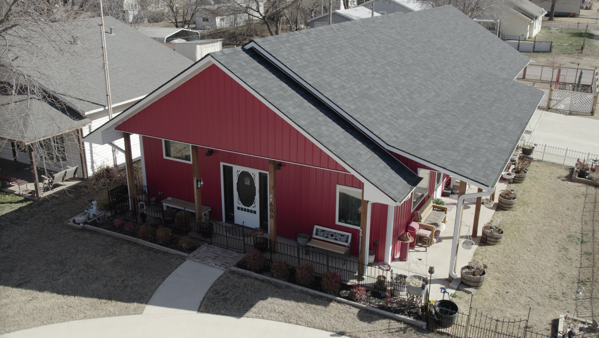 Red building with gray roof and porch; exterior view.