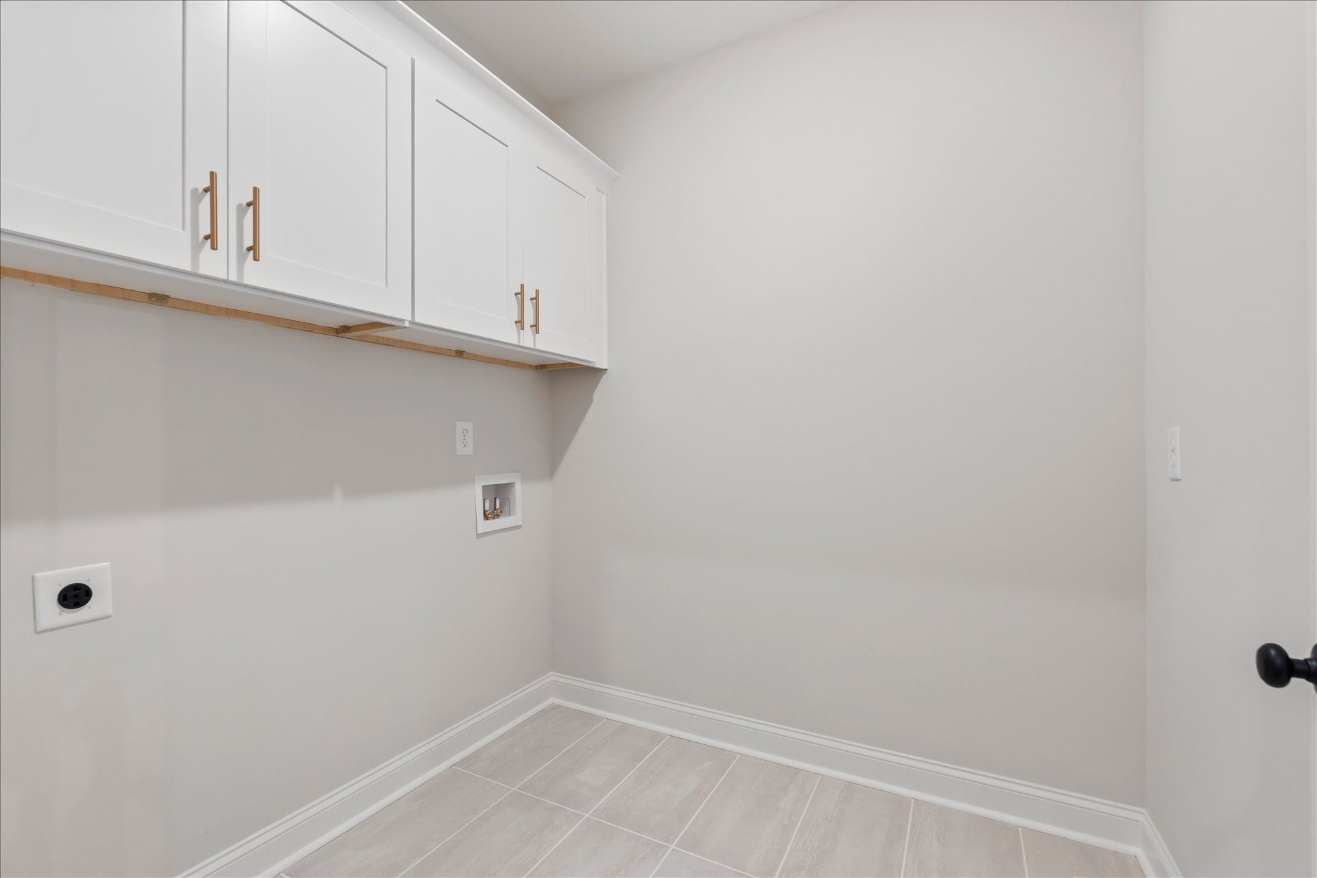 White laundry room with wall cabinets, utility hookups, and light wood flooring