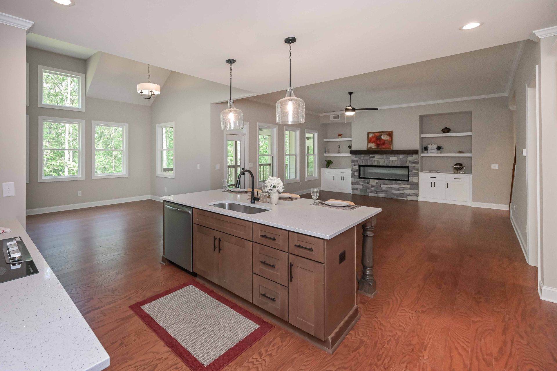 Bright modern kitchen with island, pendant lights, hardwood floors, and stainless steel appliances