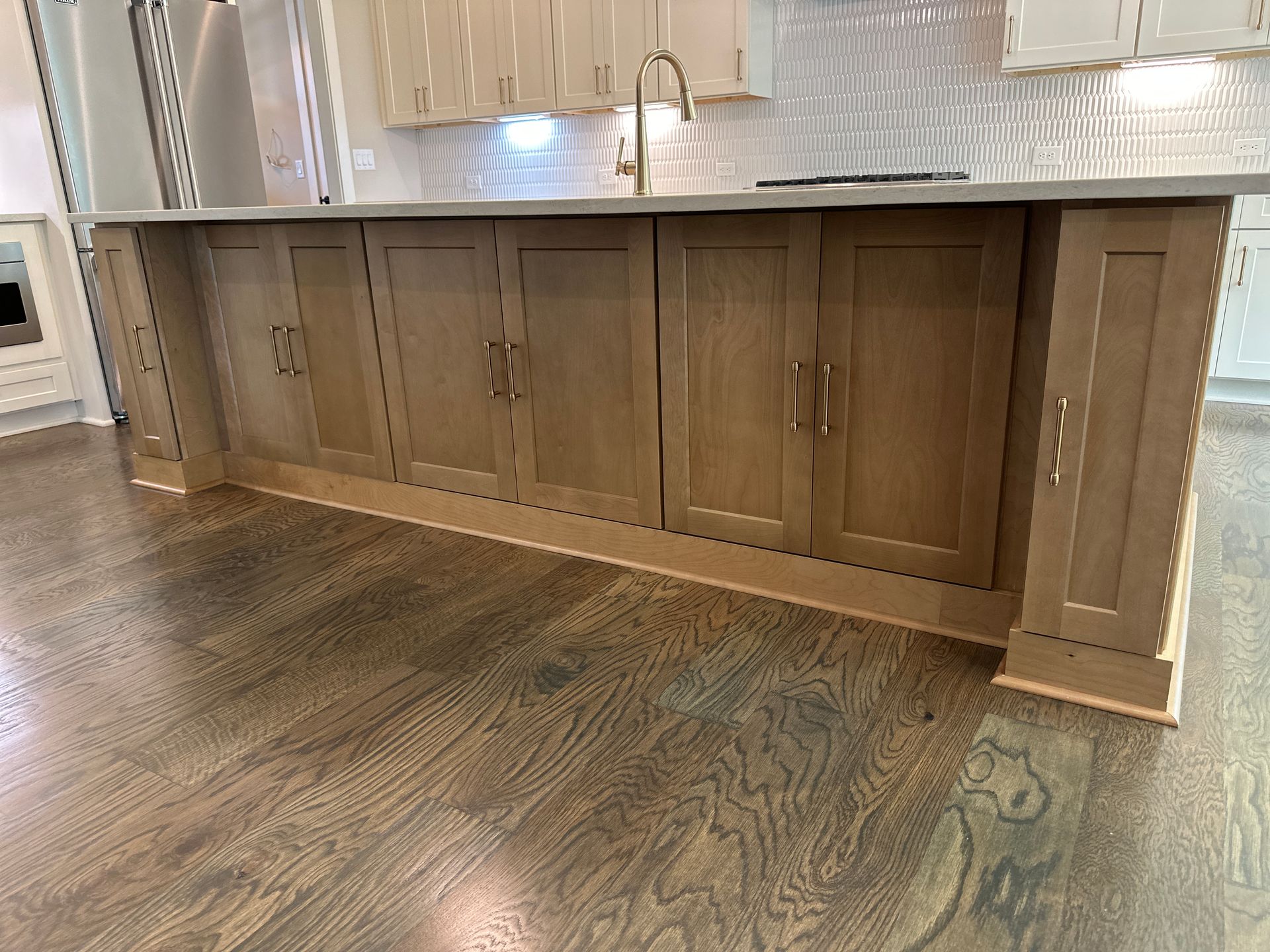 Wooden kitchen island cabinets with beige countertops in a modern kitchen