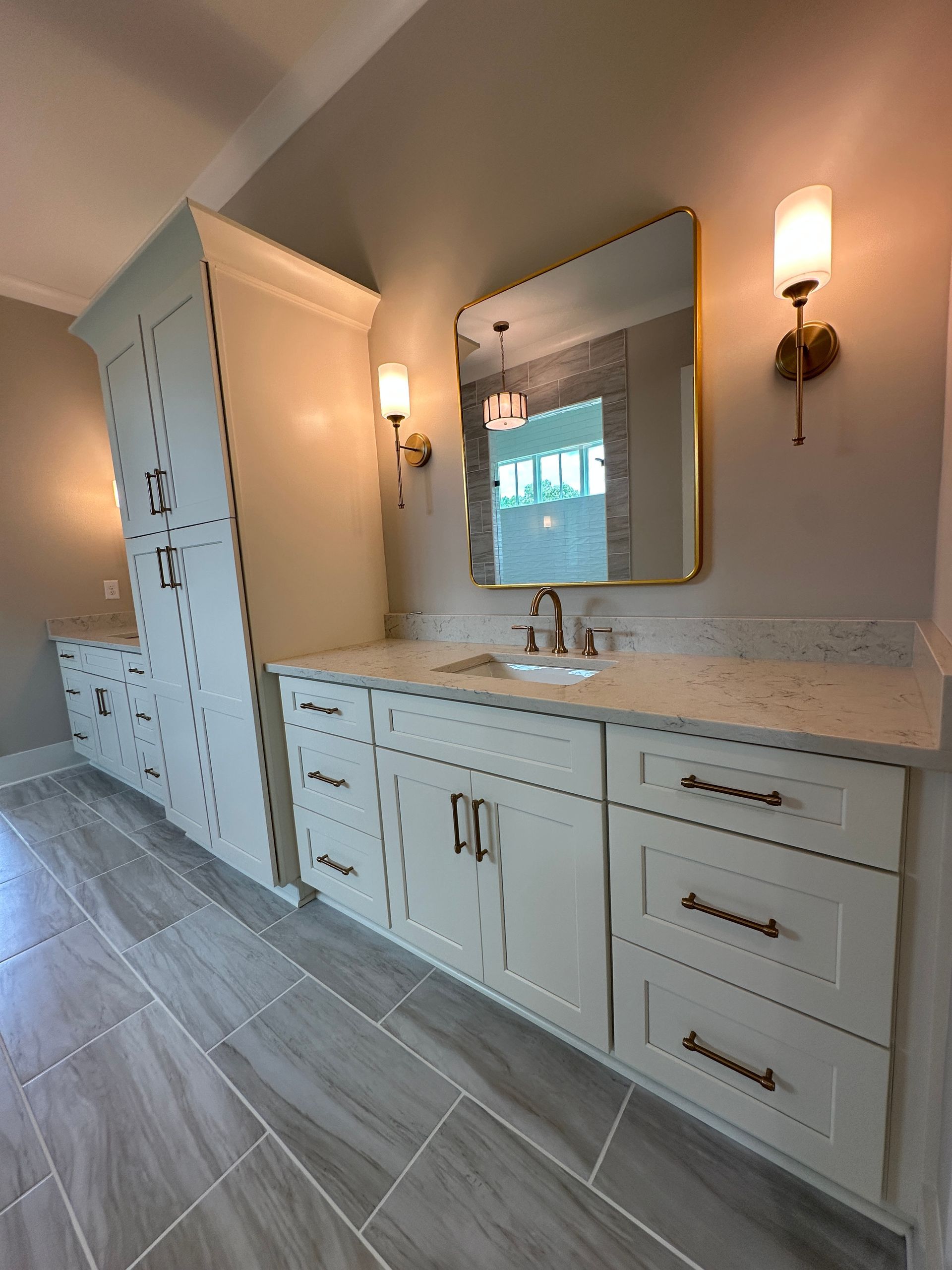 Luxurious bathroom vanity with double sinks, mirror, and white cabinets in a tiled room