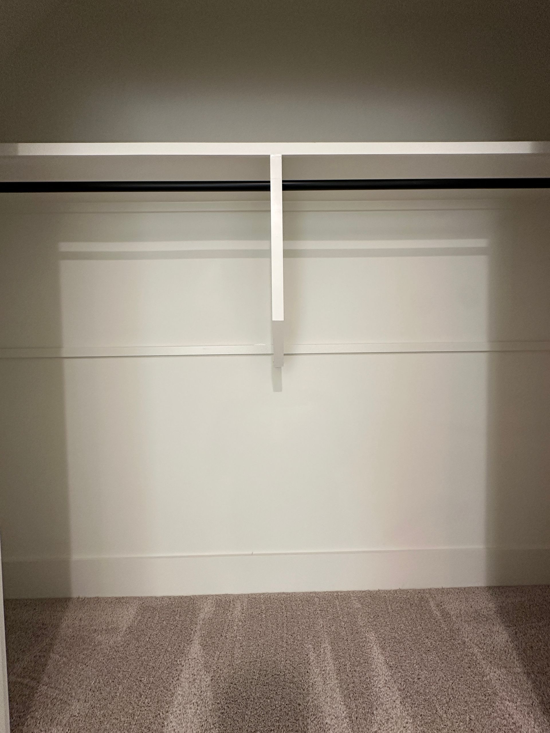 Empty closet with white shelves and carpeted floor