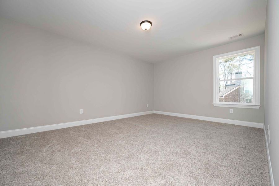 Empty room with gray walls, carpet, and a window.