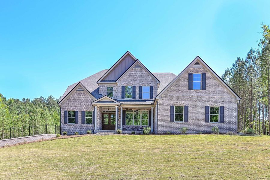 Two-story brick home with blue shutters and clear sky.