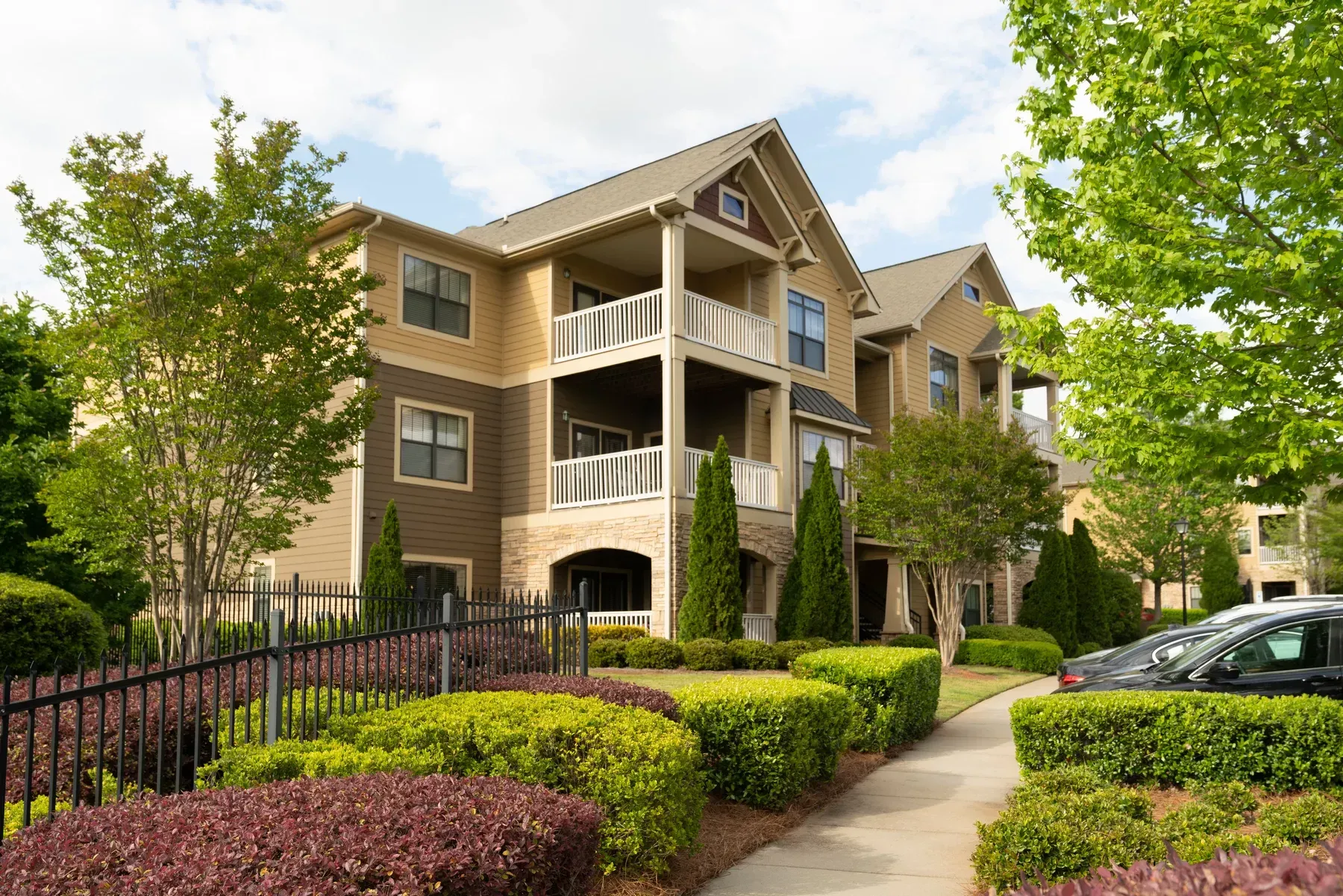 A large apartment building with cars parked in front of it.