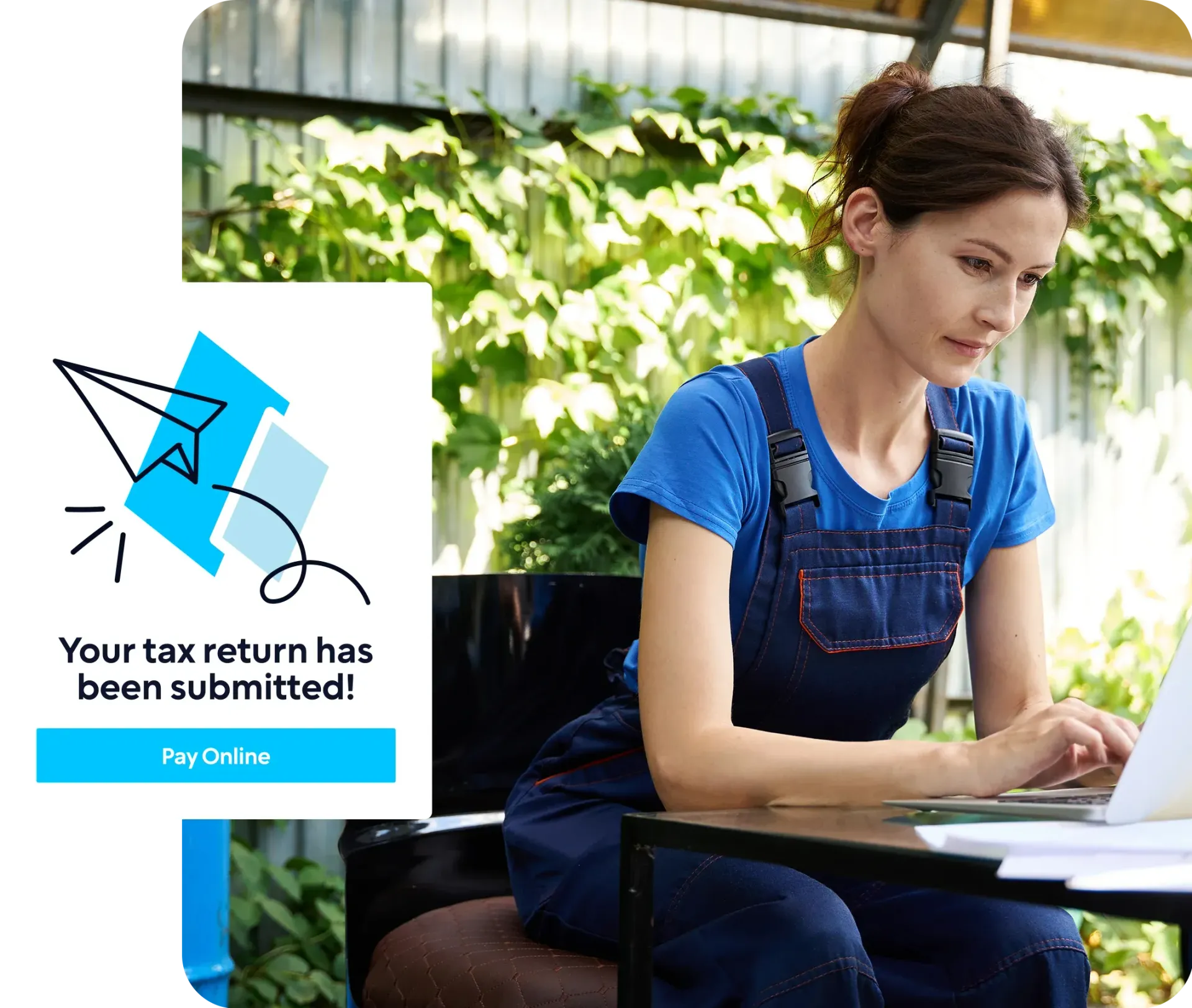 A woman is sitting at a table with a laptop and a notification that her tax return has been submitted