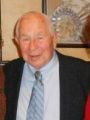 A man in a suit and tie is smiling for the camera.
