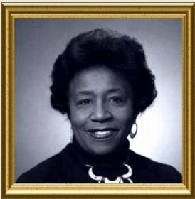 Portrait of a woman with dark hair and a smiling expression, wearing a necklace; framed.