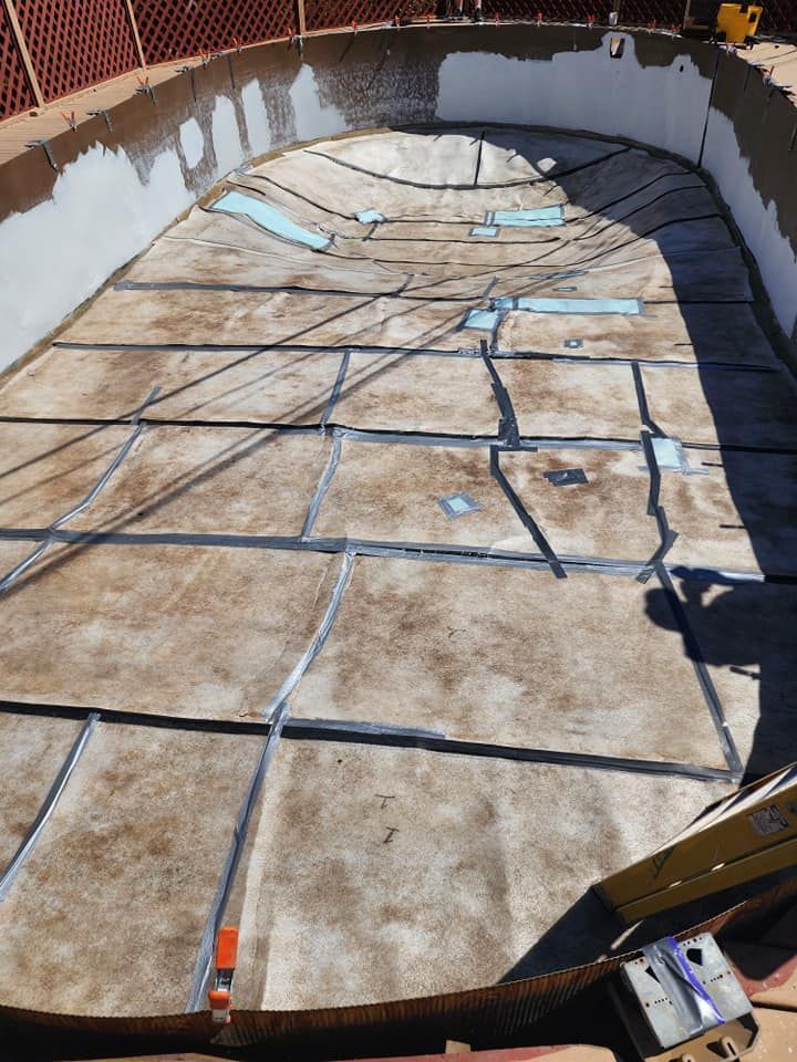Empty in-ground pool being renovated, with concrete and framing visible.