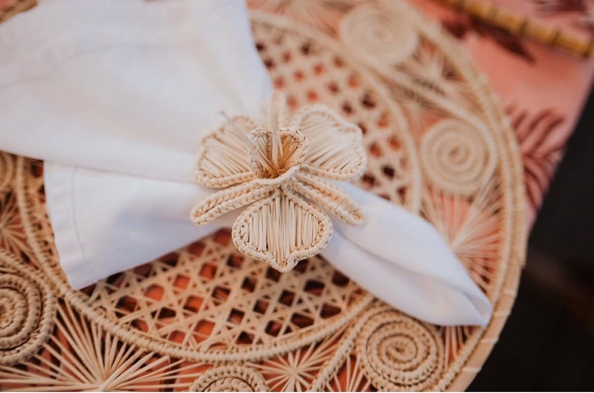 White napkin tied with a woven twine ring on a beige lace placemat