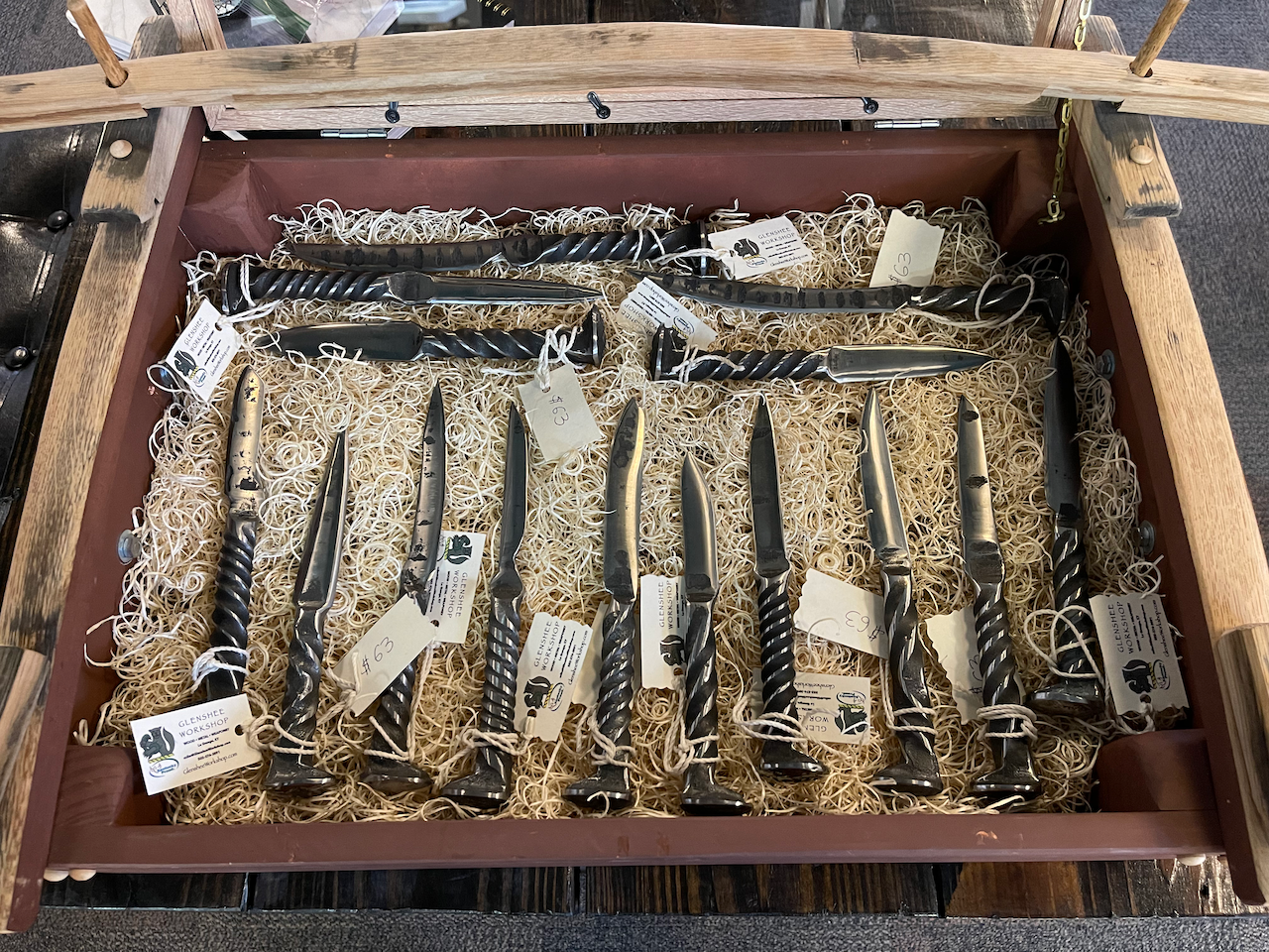 A wooden box filled with knives on a table.