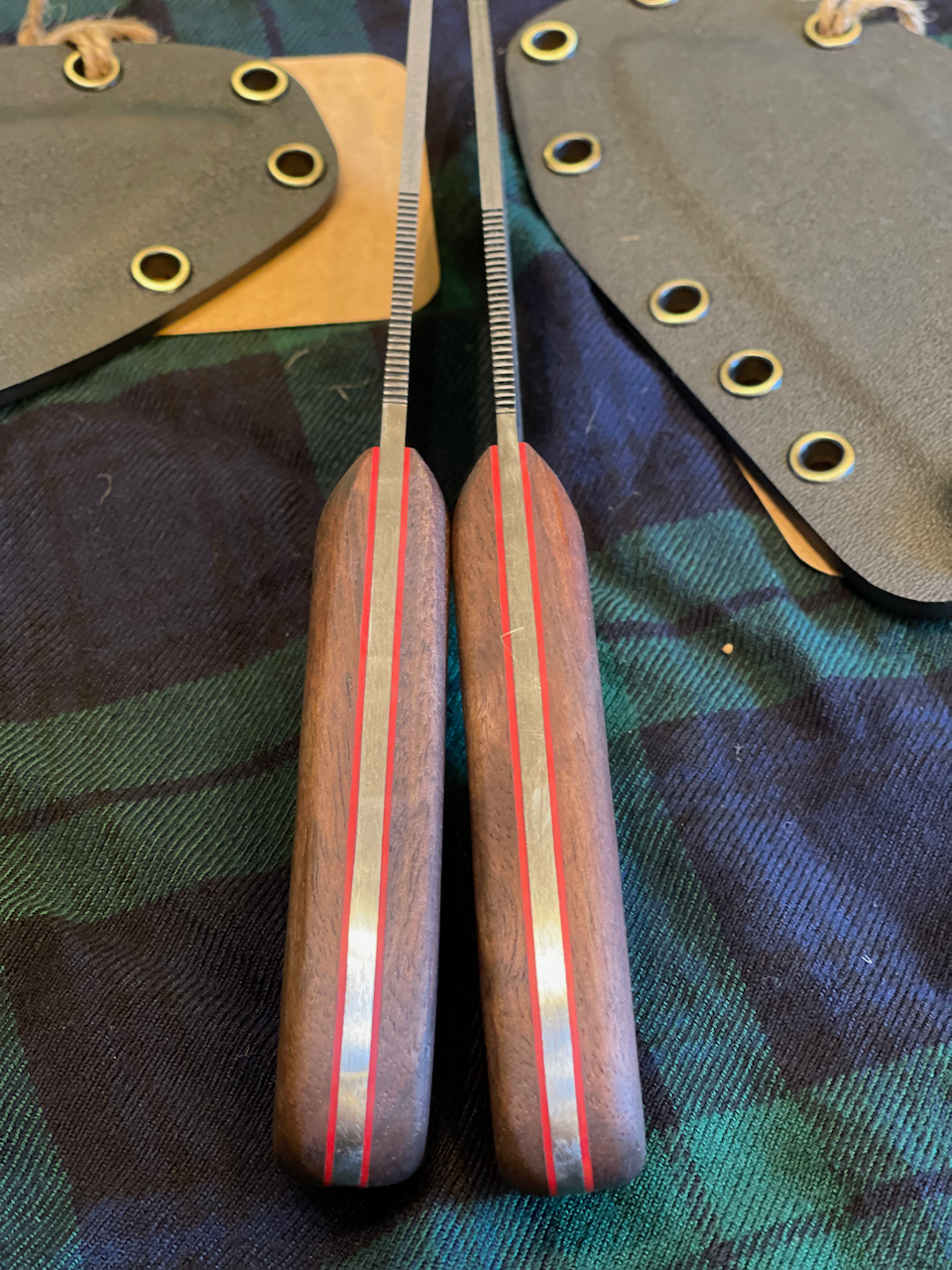 A pair of knives with red stripes on the handles