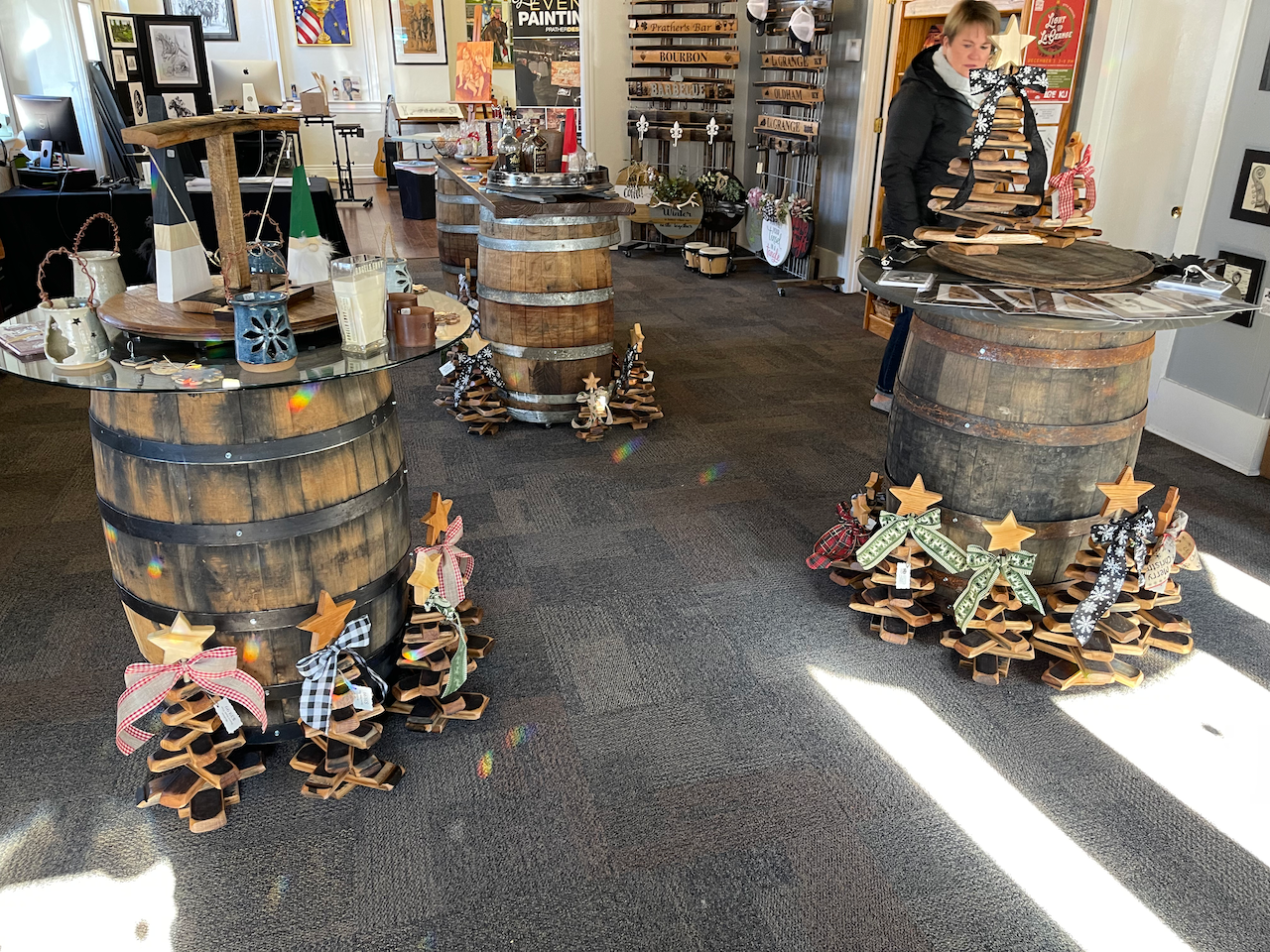Two wooden barrels are decorated with christmas trees in a store.