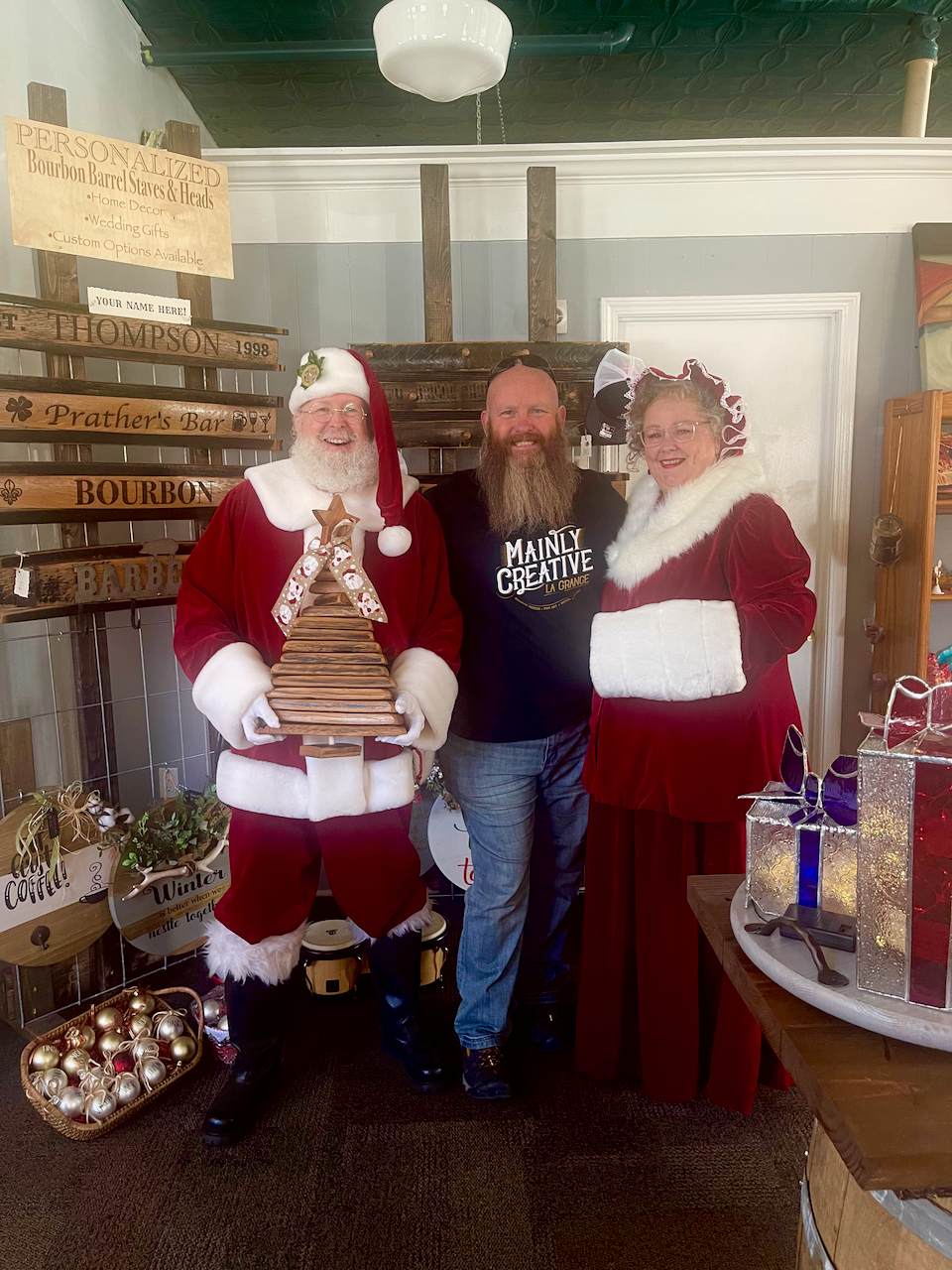 Two men and a woman dressed as santa claus are posing for a picture.