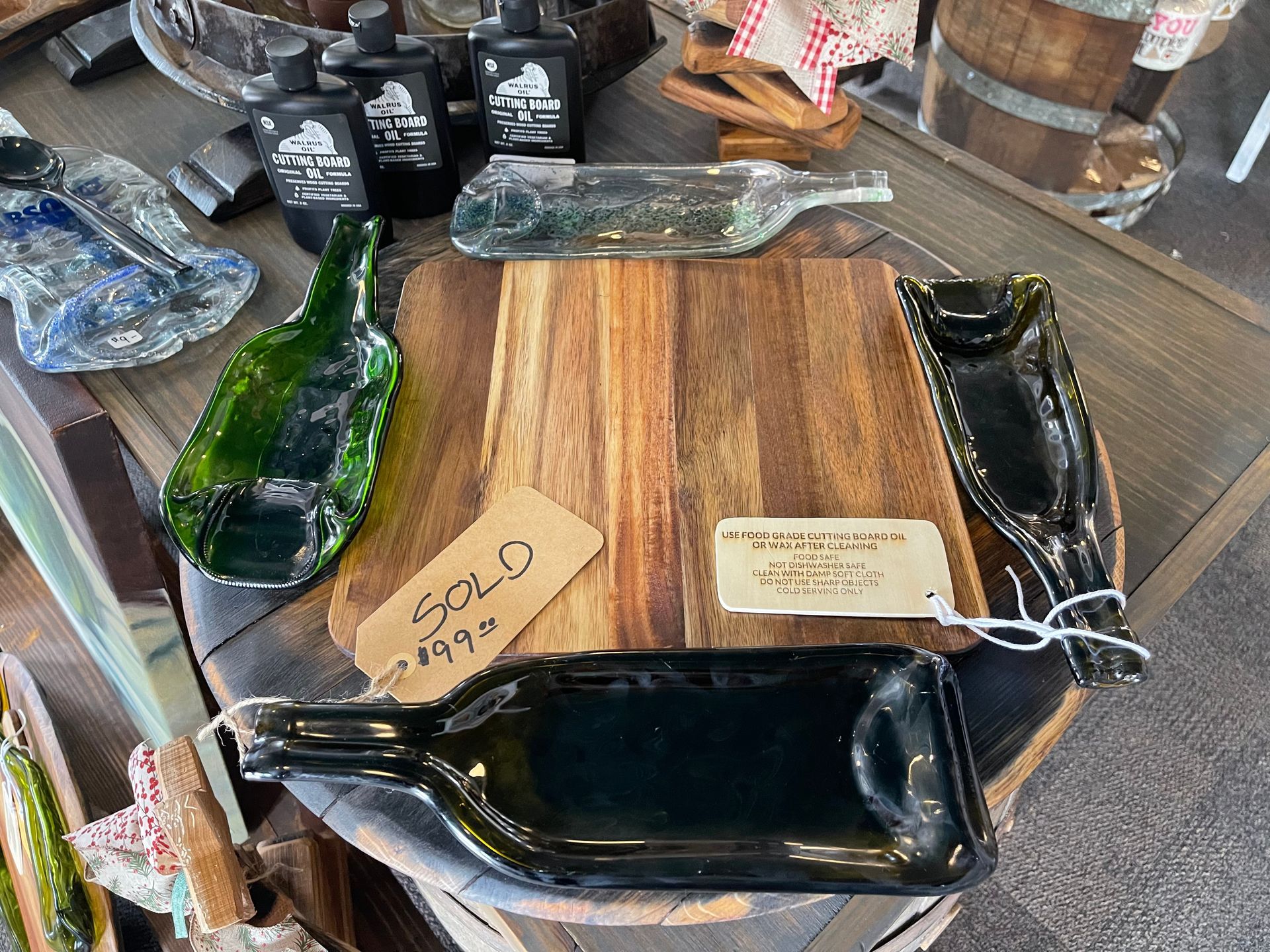 A wooden cutting board with two plates made out of wine bottles.