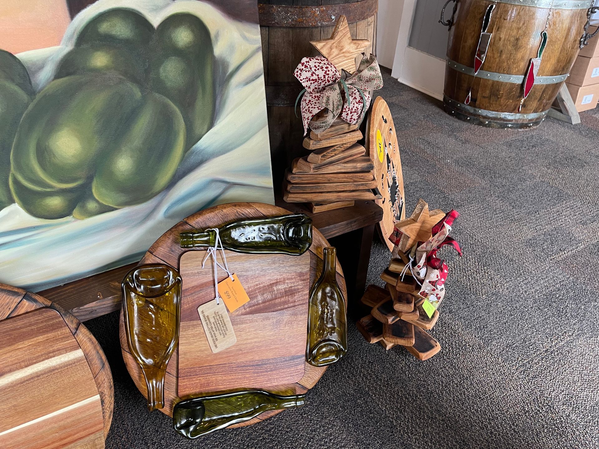 A painting of green peppers is behind a wooden barrel