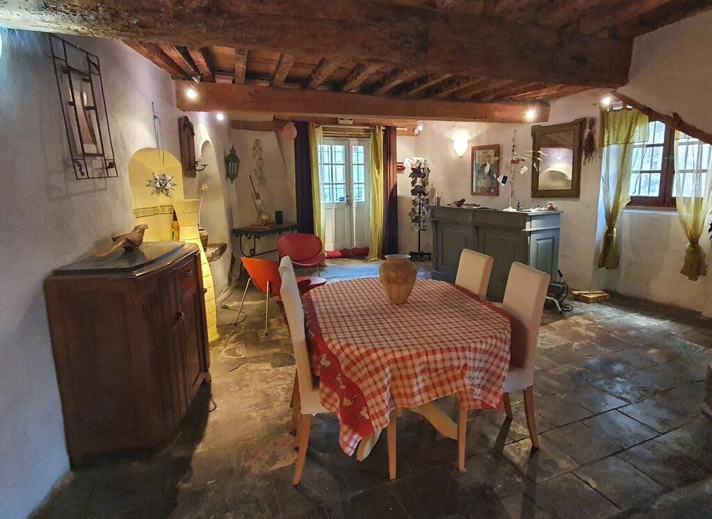 Cuisine rustique et chaleureuse avec nappe à carreaux, poutres apparentes et éclairage tamisé