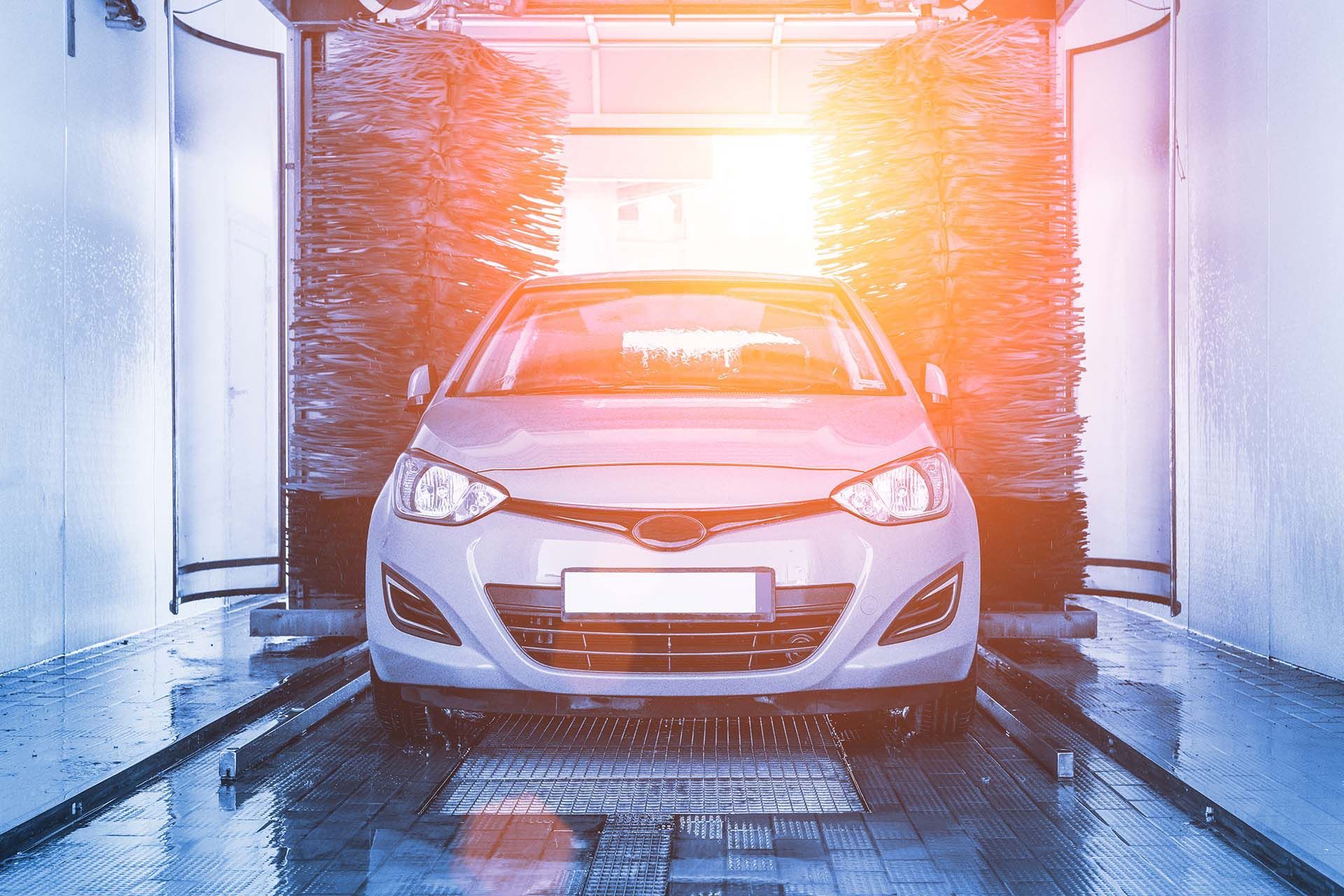 Auto brush washer clean blue car on automatic carwash station. Auto brush washer clean blue car on automatic carwash station.