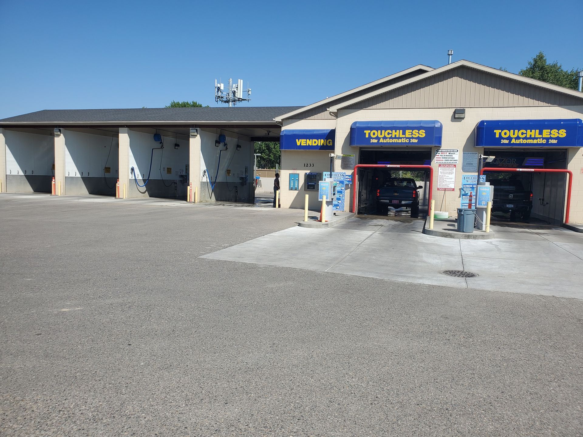 Auto service bay exterior with blue-and-yellow signs and open garage doors on a sunny day